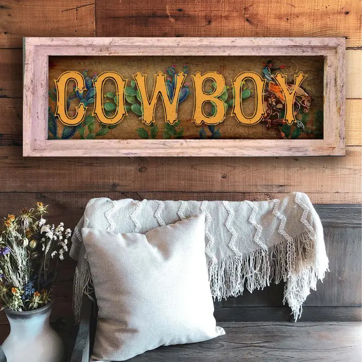 western wall decor with 'COWBOY' on a wooden wall above a couch with pillows and a blanket.
