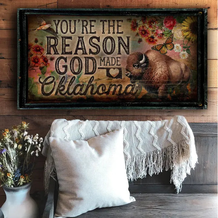 Western wall art with a bison and text on a wooden wall above a couch.