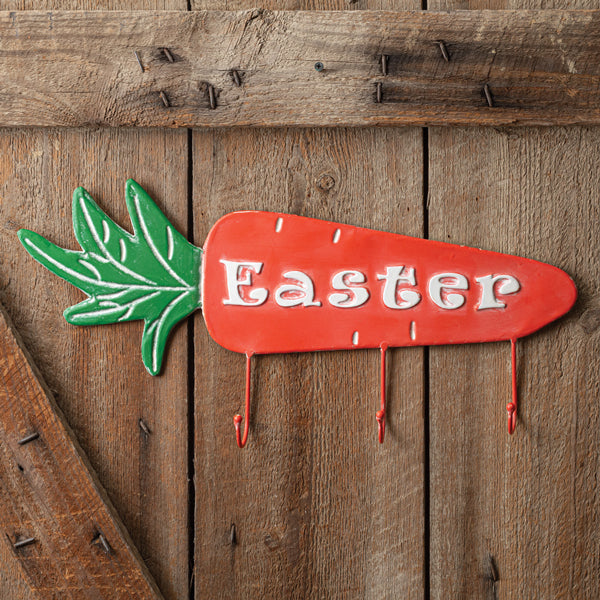 Red Easter carrot sign with green leaves on a wooden background