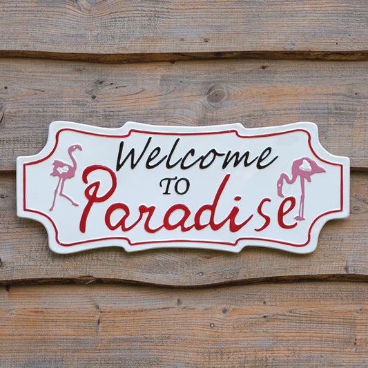 Decorative sign with 'Welcome to Paradise' text on a wooden background