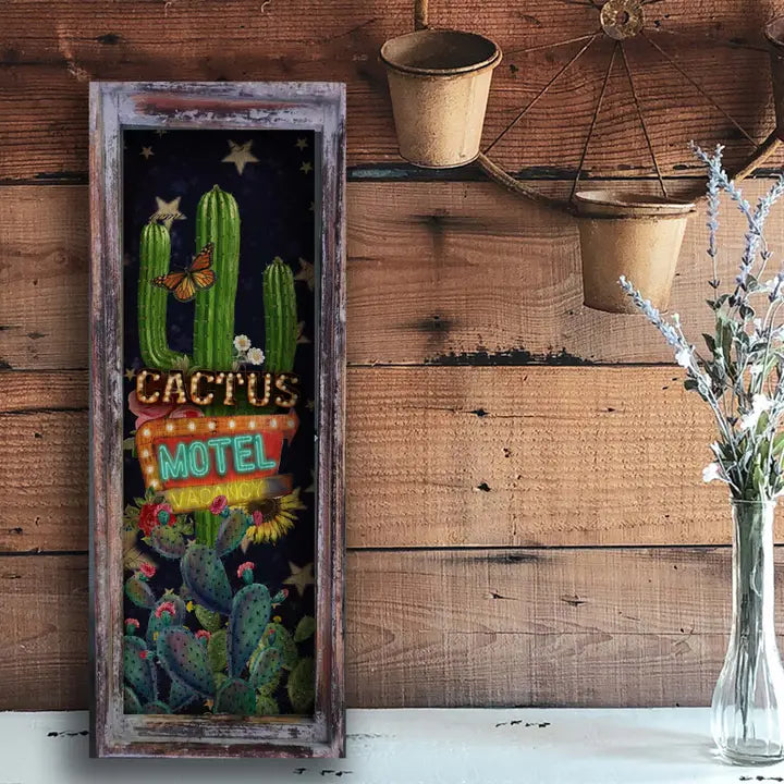 Western wall art with cactus design and 'Cactus Motel' text on a wooden wall.
