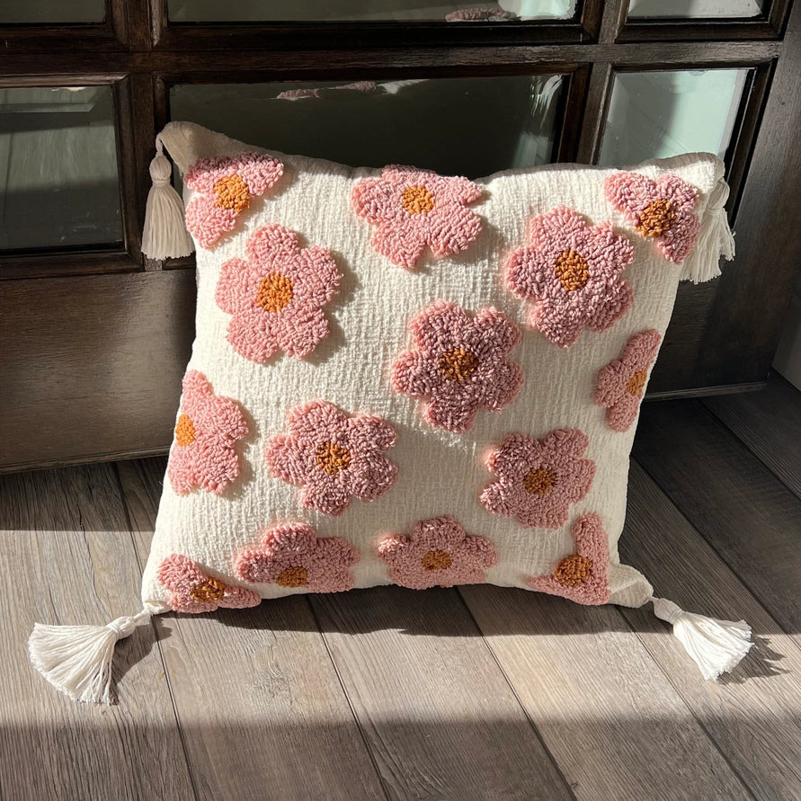 Decorative pillow with pink floral patterns on a wooden floor