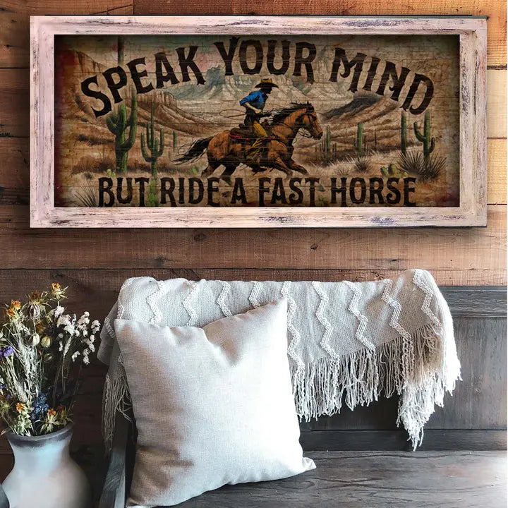western wall art with a horse and rider graphic and text above a cozy living room setting.
