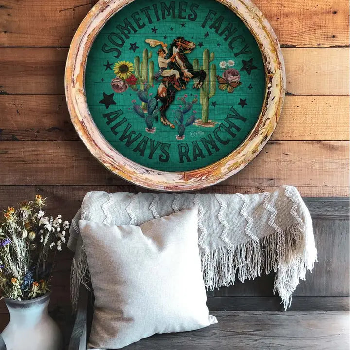 Western wall art with cowboy and horse design on a wooden wall above a couch.