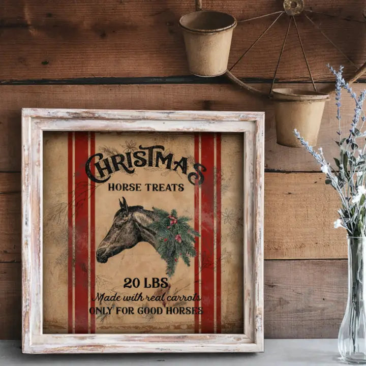Framed vintage-style Christmas sign with horse illustration and text on a wooden wall.