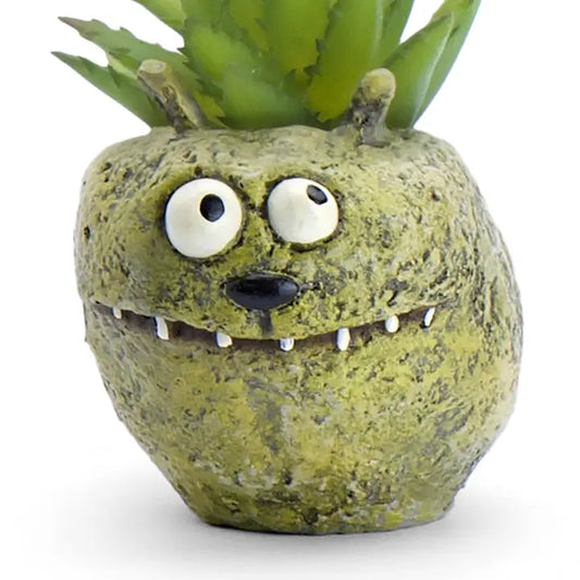 Monster-shaped planter with a succulent on a white background