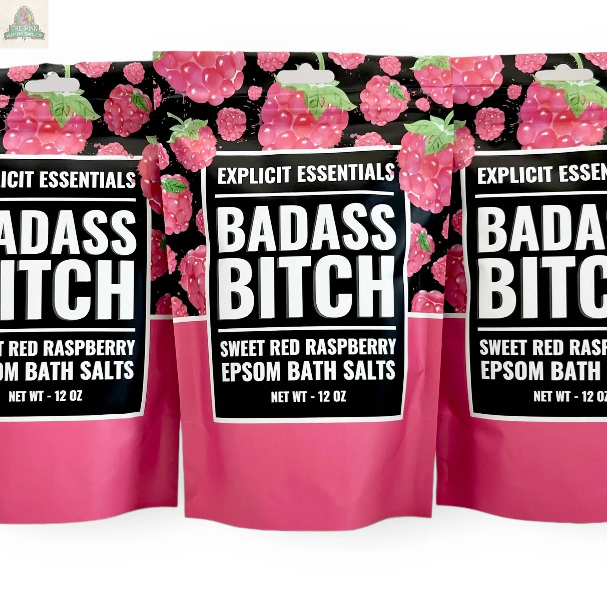 Three 12oz bags of Explicit Essentials' Bad Ass Bitch Bath Salts are shown with bold raspberry-themed packaging—an ideal, fun self-care gift for anyone who loves to unwind.