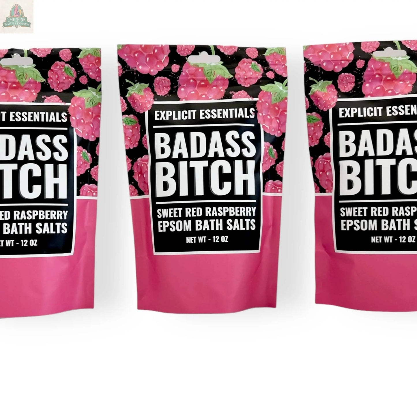 Three pink and black 12oz Bad Ass Bitch Bath Salts bags by Explicit Essentials, labeled Sweet Red Raspberry Epsom Salts with raspberry images and bold white text—perfect for self-care or as a thoughtful gift.