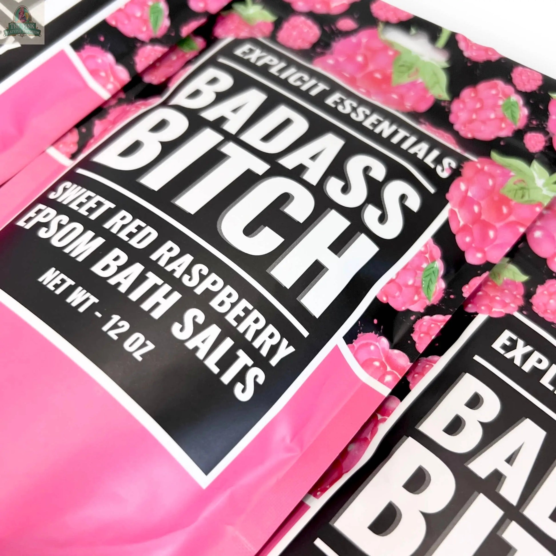 Close-up of Bad Ass Bitch Bath Salts 12oz Bag by Explicit Essentials, showing vibrant raspberry-themed packaging with bold white lettering on a pink and black background. Made with Epsom salts—great for self-care or gifting.