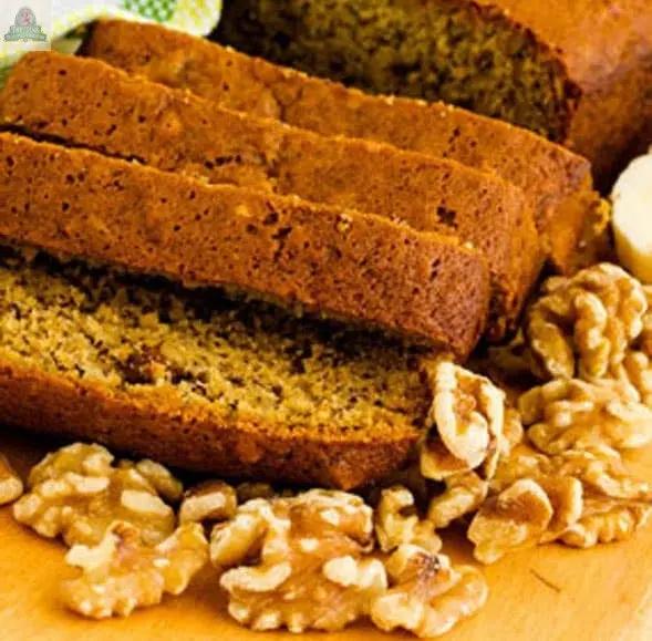 Sliced banana bread on a wooden surface, walnuts scattered nearby, as the inviting scent of Banana Nut Bread Atomizer Oils fills the air.