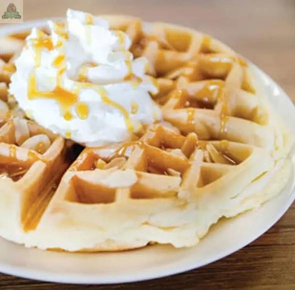 The sweet aroma of Belgian Pecan Waffles Atomizer Oils fills the air, evoking golden waffles with whipped cream and caramel sauce served on a white plate atop a wooden table.
