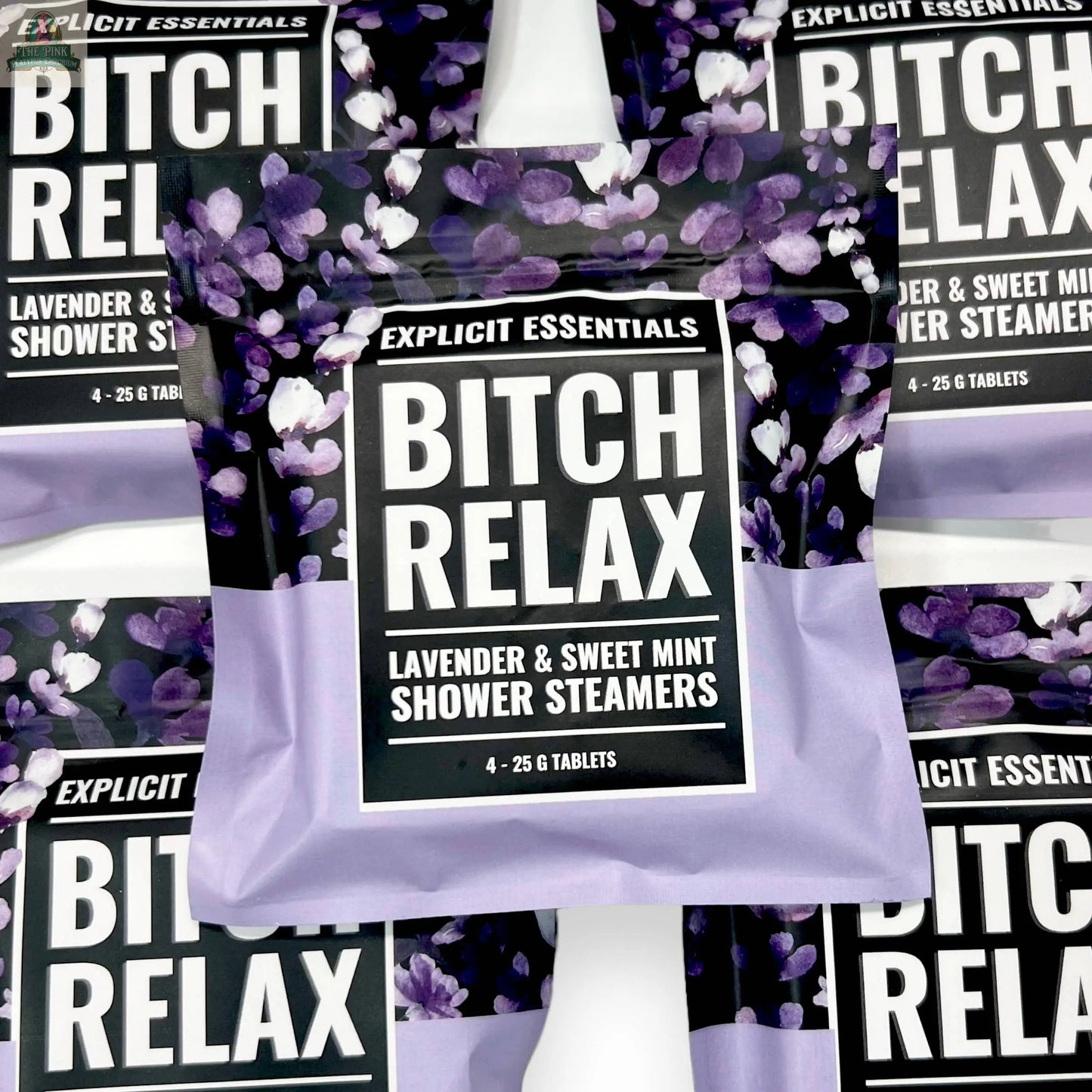 Several packages of Explicit Essentials Bitch Relax Shower Steamers are displayed, showcasing bold black and white labels with purple floral designs—a perfect self-care gift for relaxation.