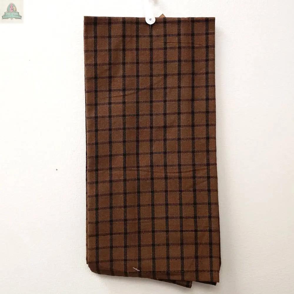 The Black Large Check Kitchen Towel (15 x 25, cotton) with a black check pattern hangs from a small hook on a white wall.