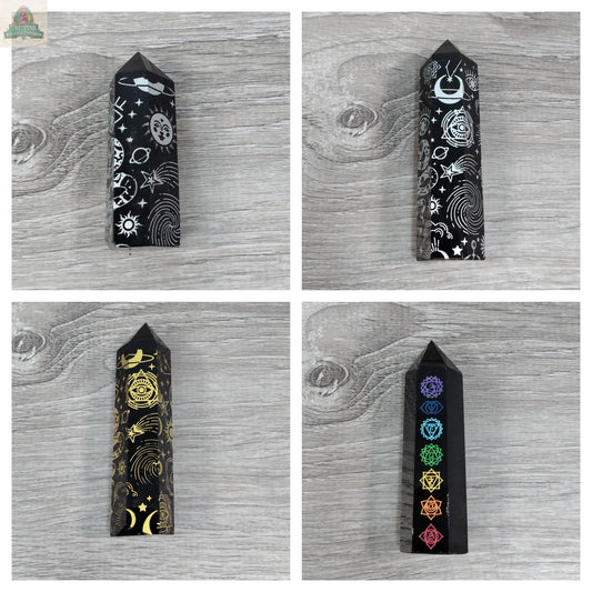 Four Keystone Crystals Black Obsidian Chakra Obelisks from Pink Platypus Emporium, each etched with moons, stars, gold symbols, and vibrant chakra designs, are displayed in a 2x2 grid for energy protection and chakra alignment.