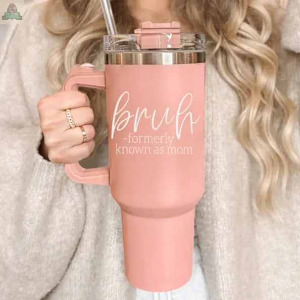A woman with long, wavy blonde hair holds a Bruh Pink 40oz tumbler with handle—the perfect mom gift, featuring "bruh - formerly known as mom" in white script.