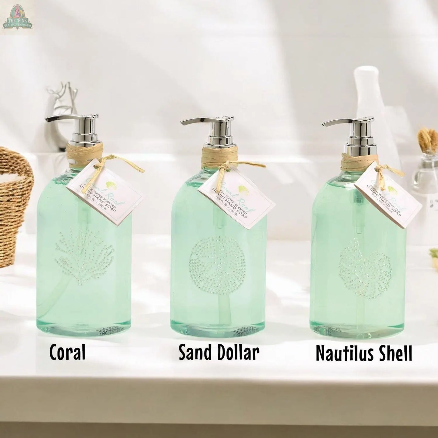 By the Sea Hand Soap: Set of 3 clear reusable pump dispensers, each with a unique sea-themed design—coral, sand dollar, and nautilus shell—perfect as labeled beach bathroom decor on your counter.