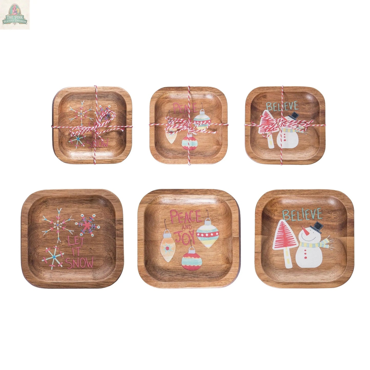 Decorative Wood Plates for Christmas feature festive designs like snowmen, ornaments, snowflakes, and phrases such as “Let It Snow,” “Peace and Joy,” and “Believe.” Some plates are tied with red and white string.