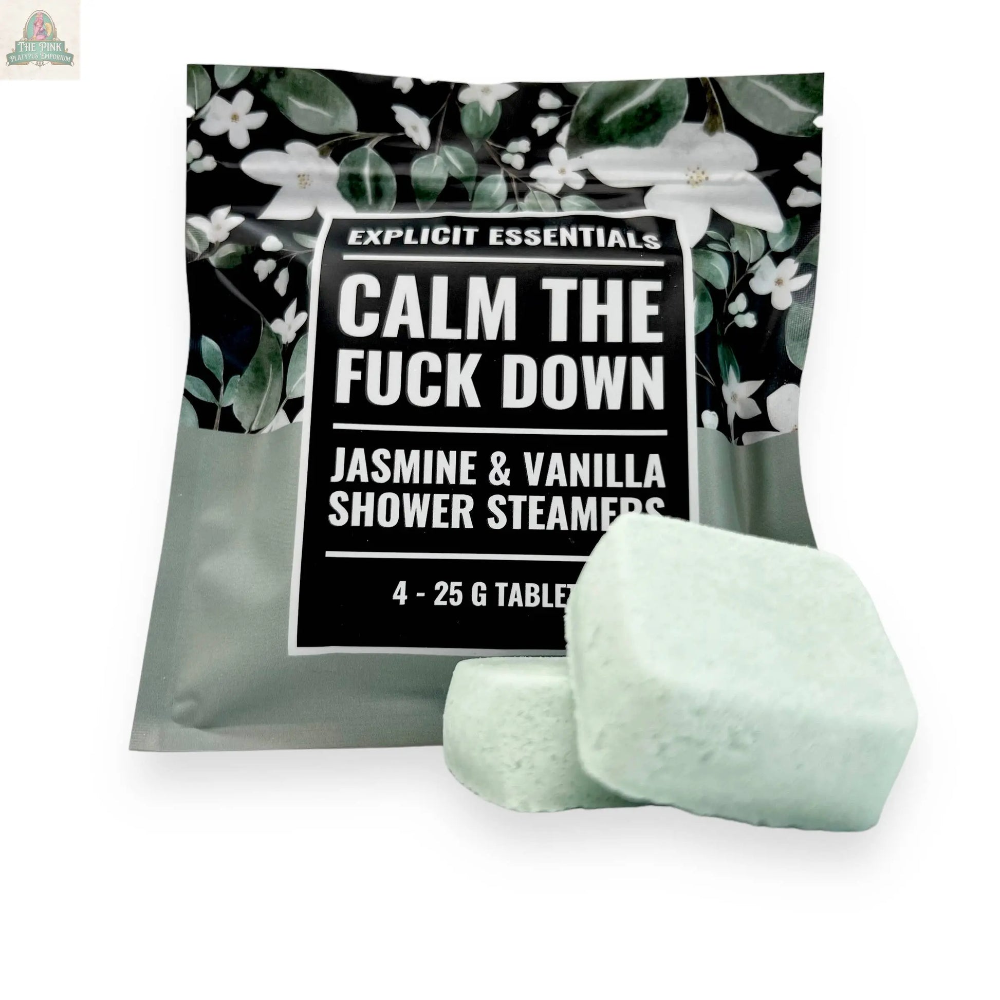 A package of Explicit Essentials Calm TF Down Shower Steamers displays a floral design on top, with two light green square steamers in front. The scent is jasmine and vanilla.