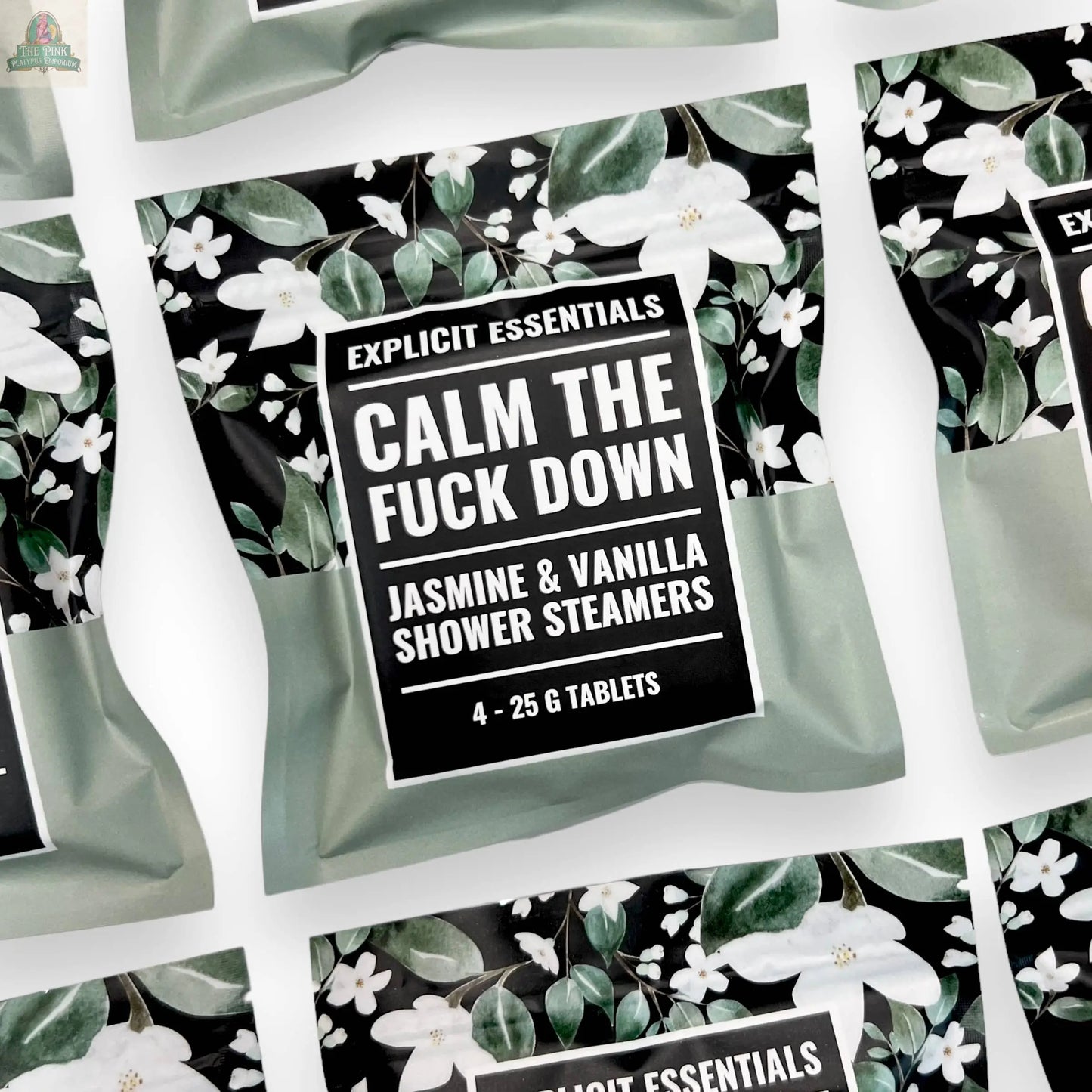 A flat lay of multiple Explicit Essentials Calm TF Down Shower Steamers packs, each with a floral design and containing four 25g tablets for a soothing jasmine and vanilla aromatherapy shower experience.