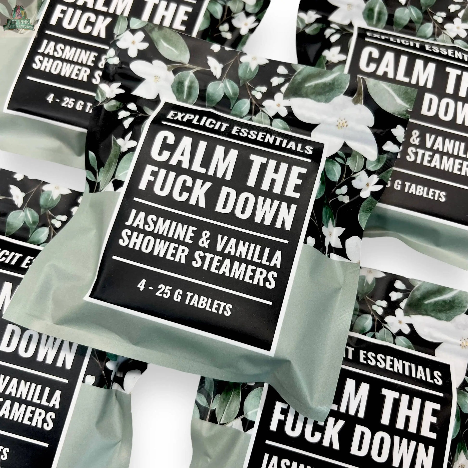 Multiple packs of Explicit Essentials' Calm TF Down Shower Steamers, featuring a green and black floral design; each pack includes four 25g aromatherapy steamers in relaxing jasmine and vanilla.