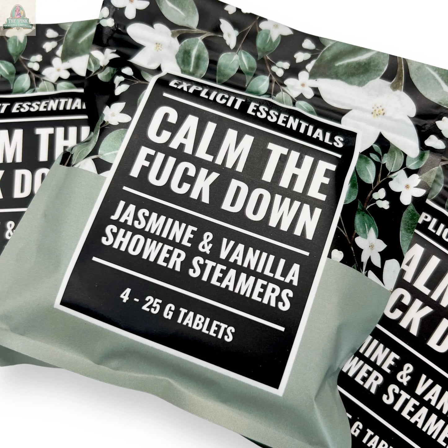 Explicit Essentials Calm TF Down Shower Steamers feature a jasmine & vanilla scent. Each pack includes four 25g tablets, packaged with white flowers and green leaves for an aromatherapy shower experience.