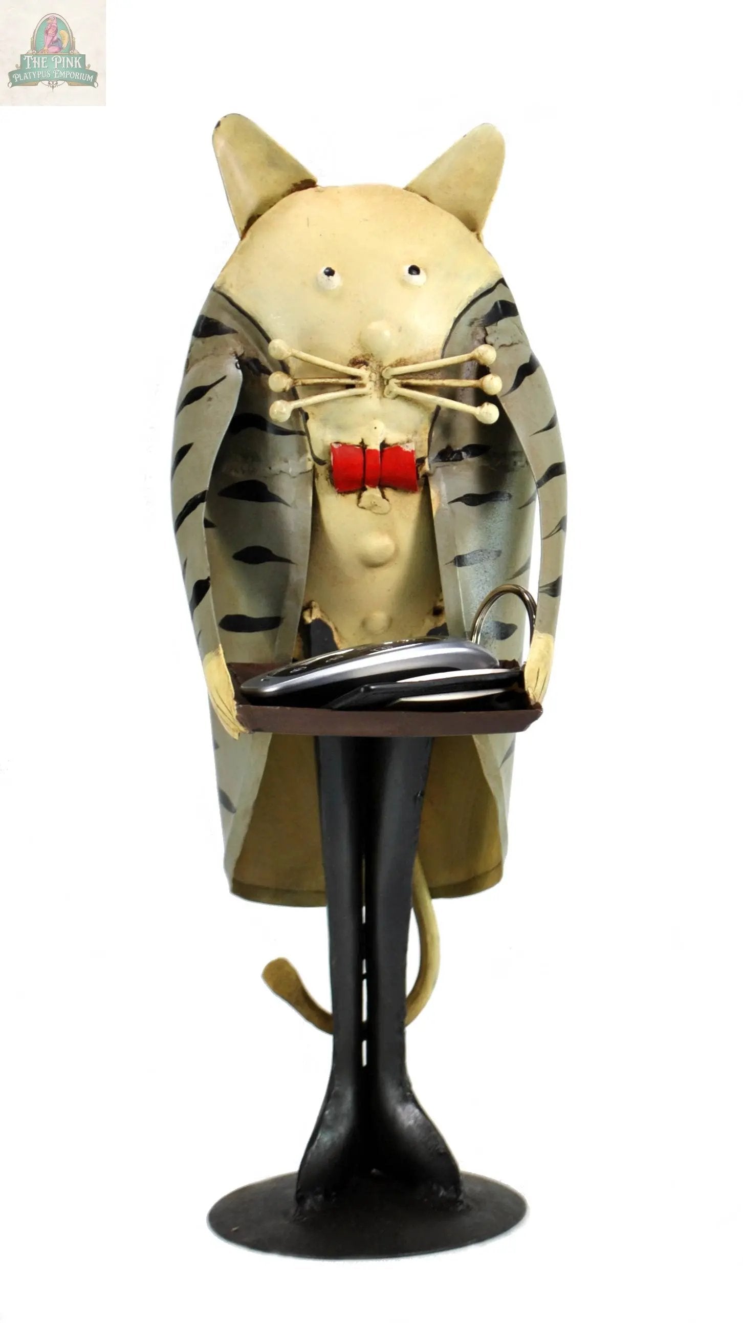 The Cat Butler with tray figurine is a whimsical 13" vintage décor piece made of iron, featuring exaggerated facial features and a striped coat, and holds a decorative cat tray with a silver fish.