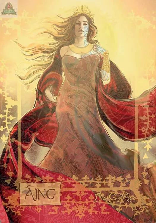A regal woman with long hair wears a crown and red-gold gown amid golden swirls. Inspired by Celtic goddesses, "Aine" is featured below an ornate design. From the REDFeather Celtic Goddesses, Witches, and Queens Oracle deck.