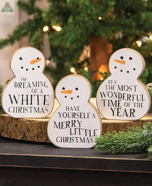 The Christmas Carol Chunky Snowman Sitter (set of 3 assorted) features festive sayings and adds charming farmhouse Christmas decor to your holiday scene.