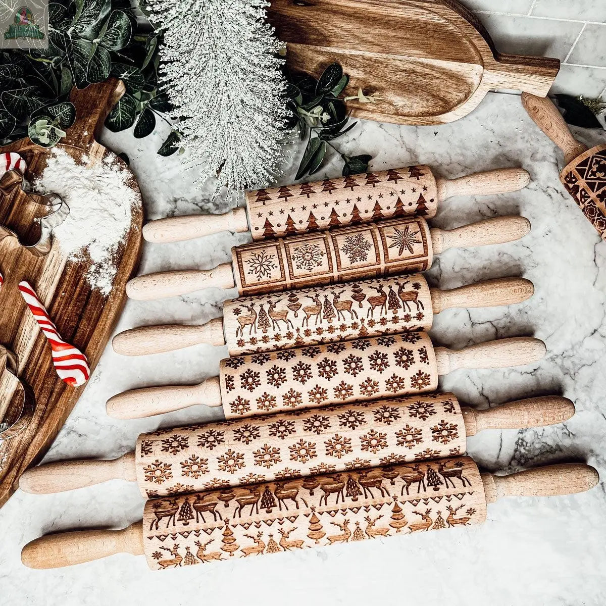 The Christmas Rolling Pin Set | 10 Styles features engraved pins with festive patterns—snowflakes, reindeer, Christmas trees—arranged with cookie cutters and baking tools, perfect as a holiday gift for bakers.