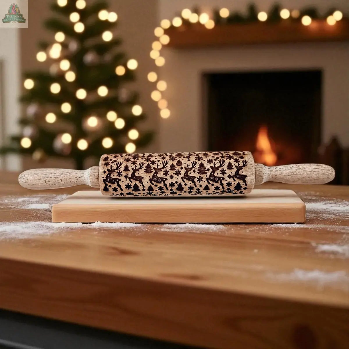 The Christmas Rolling Pin Set | 10 Styles, featuring engraved reindeer and snowflakes, sits on a wooden cutting board—an ideal baking gift. Blurred Christmas tree lights and a fireplace add to the cozy holiday scene.
