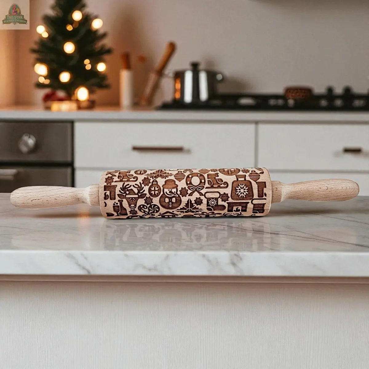 The Christmas Rolling Pin Set | 10 Styles features engraved festive patterns, perfect for holiday baking gifts. It sits on a kitchen counter with a small decorated Christmas tree and kitchen items in the background.