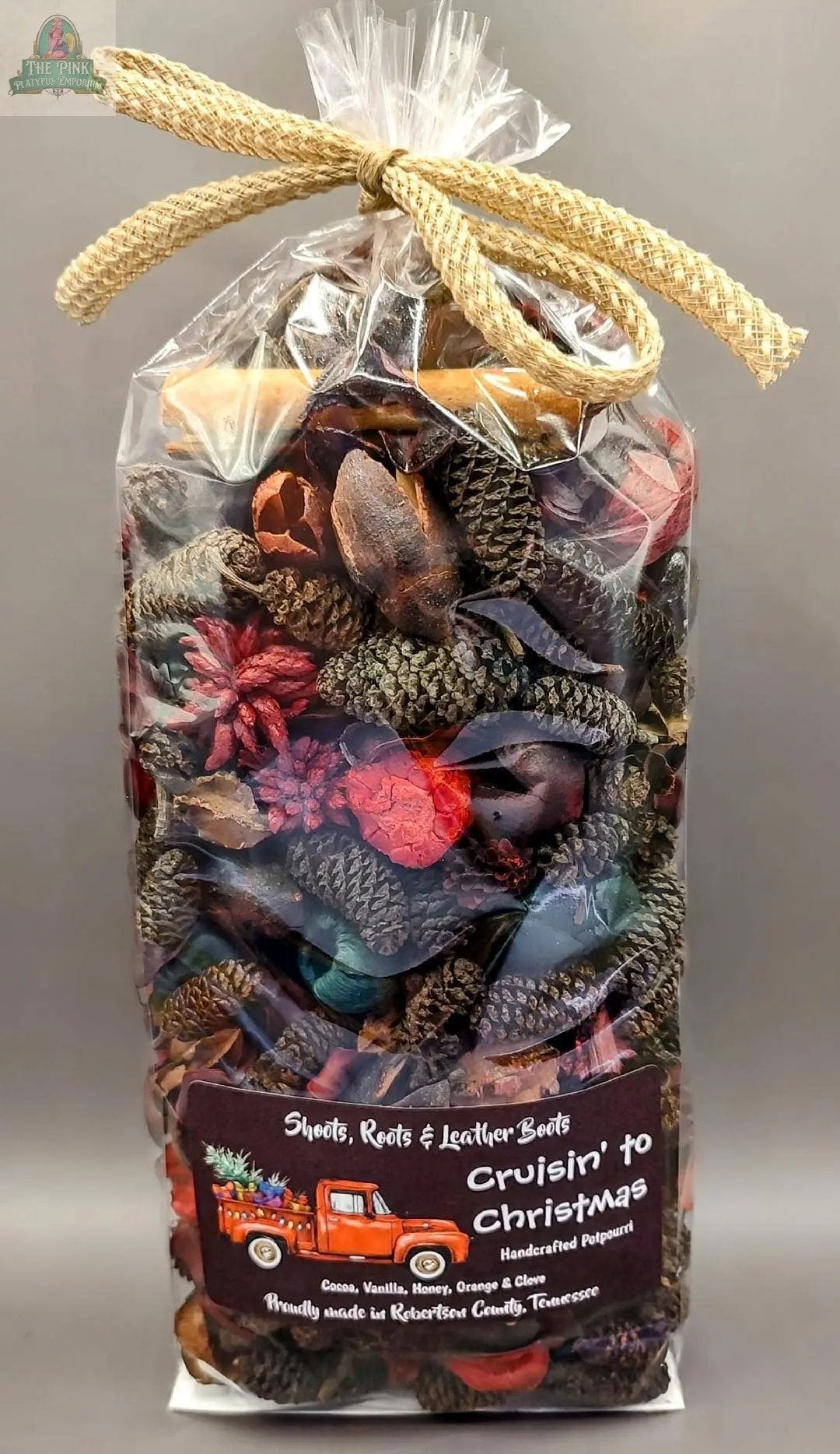 Cruisin' to Christmas Handcrafted Potpourri (5 cups) comes in a clear plastic bag with pine cones, dried botanicals, and a burlap bow. The festive label features a red truck with holiday decor—perfect as a home fragrance or bowl filler.