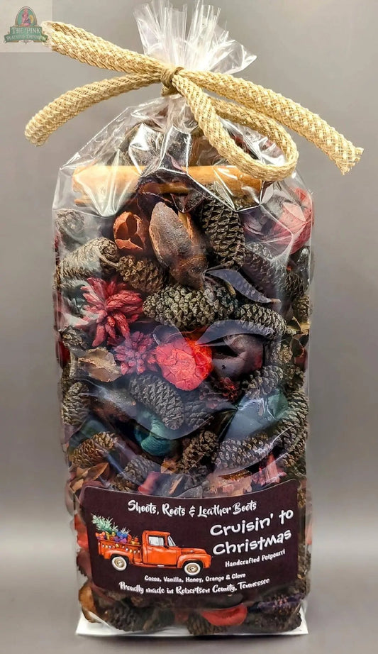 Cruisin' to Christmas Handcrafted Potpourri (5 cups) comes in a clear plastic bag with pine cones, dried botanicals, and a burlap bow. The festive label features a red truck with holiday decor—perfect as a home fragrance or bowl filler.