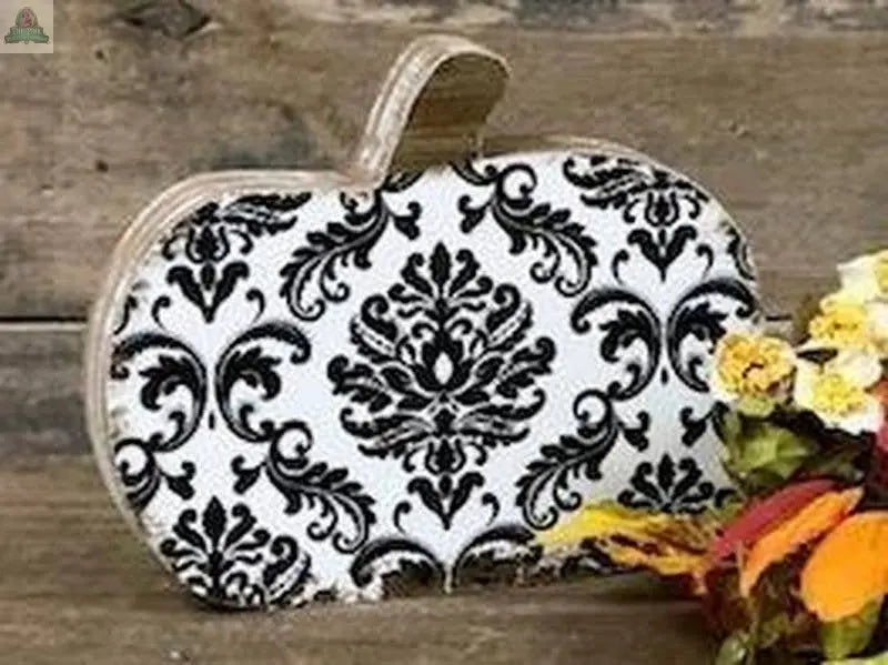 The Damascus Print Pumpkin sits on a wooden surface, accented by a bouquet of artificial autumn flowers and leaves, creating charming fall decor.
