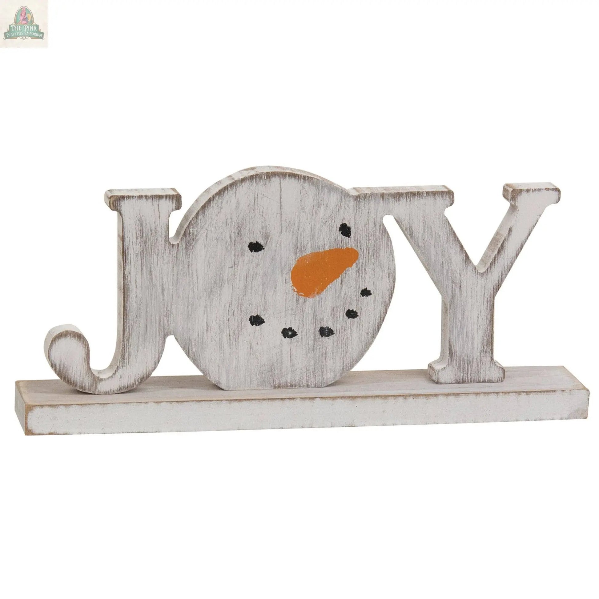 The Distressed Snowman "Joy" on Base is a winter farmhouse decor sign, featuring a snowman-shaped "O" with a carrot nose and dotted eyes and mouth.