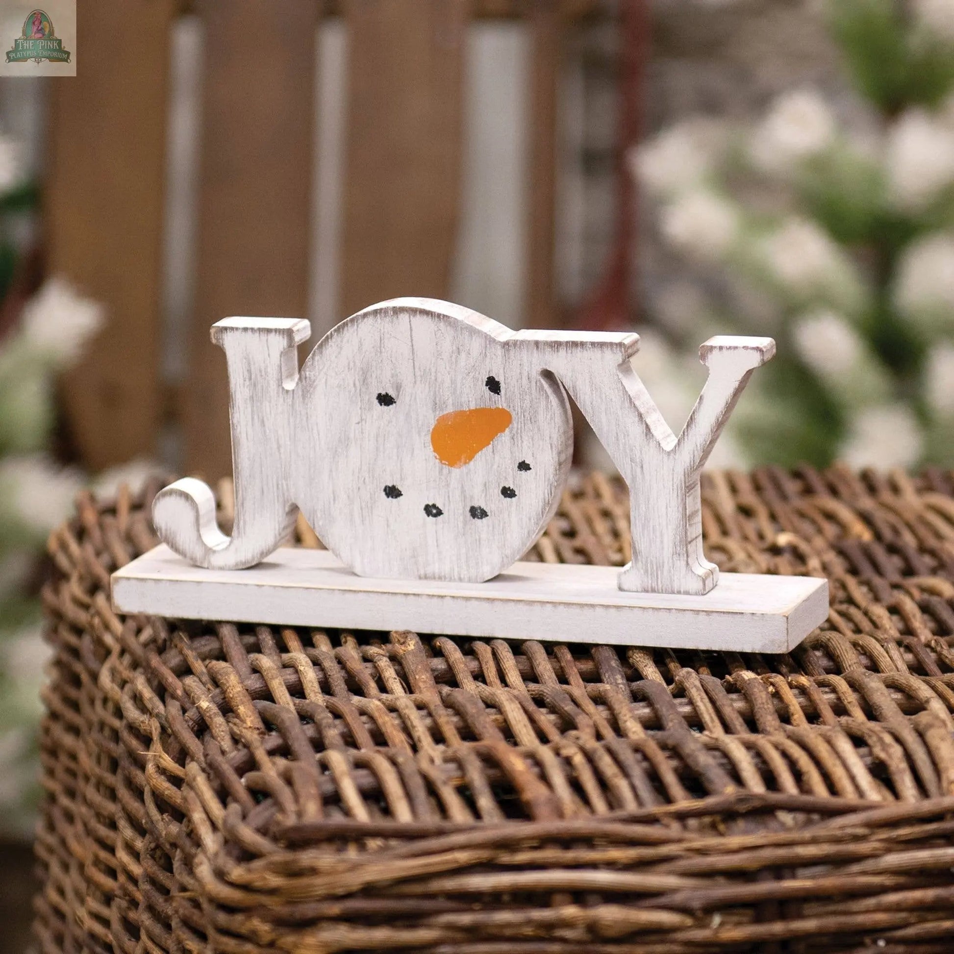 The Distressed Snowman "Joy" on Base features a snowman’s face as the "O" in Joy, with a carrot nose and coal eyes—perfect winter farmhouse decor for your home.
