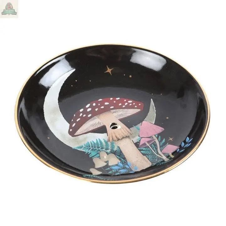 The Forest Mushroom Ceramic Incense Holder Plate is a round black plate with gold edges, featuring hand-painted red and white mushrooms, ferns, a crescent moon, and stars—ideal as mystical woodland decor or a unique gift.
