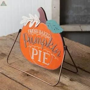 The Fresh Baked Pumpkin Pie A-Frame Tabletop Sign, shaped like a pumpkin with leaves, reads "Fresh Baked Pumpkin Pie" and is shown on a rustic wooden surface.