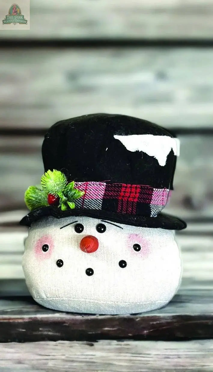 The Frosted Black Hat Snowman Head Small is a 7" plush snowman with button eyes, a carrot nose, rosy cheeks, a stitched smile, and a black hat with a red plaid band, green holly, and red berries.