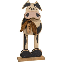 Wooden cow figurine with welcome sign on a white background