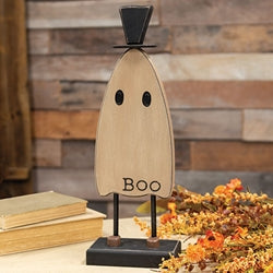 Wooden ghost decoration with 'BOO' text on a stand against a rustic wooden background.