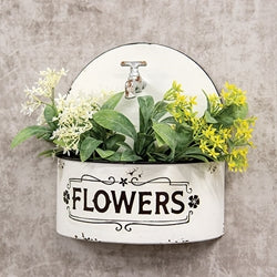 Decorative farmhouse wall planter with flowers on a textured wall background