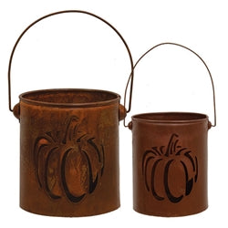 Two rust-colored metal buckets with pumpkin designs on a white background