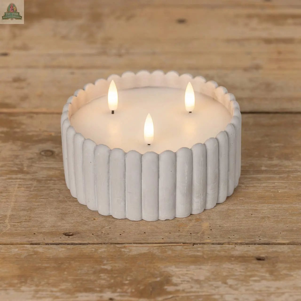 A GREY CEMENT 3 WICK 3D FLAME CANDLE shines in a sleek cement holder on a rustic wooden surface, adding warmth and charm to your space.