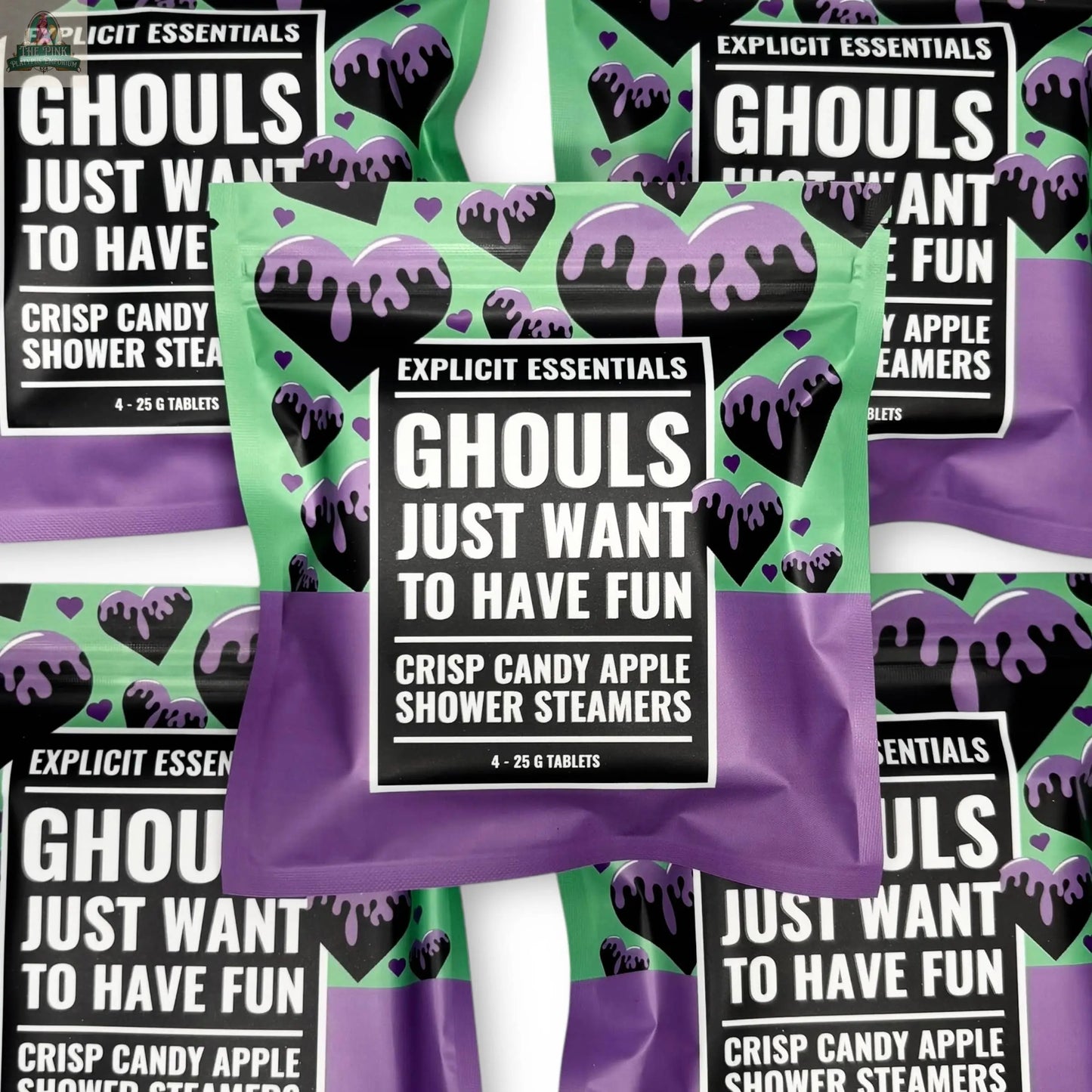 A package of Explicit Essentials Halloween Shower Steamers | Spooky Season Gift features a bold black-and-white label with a dripping green and purple design. Several packages are displayed in a fun, Halloween-themed pattern.