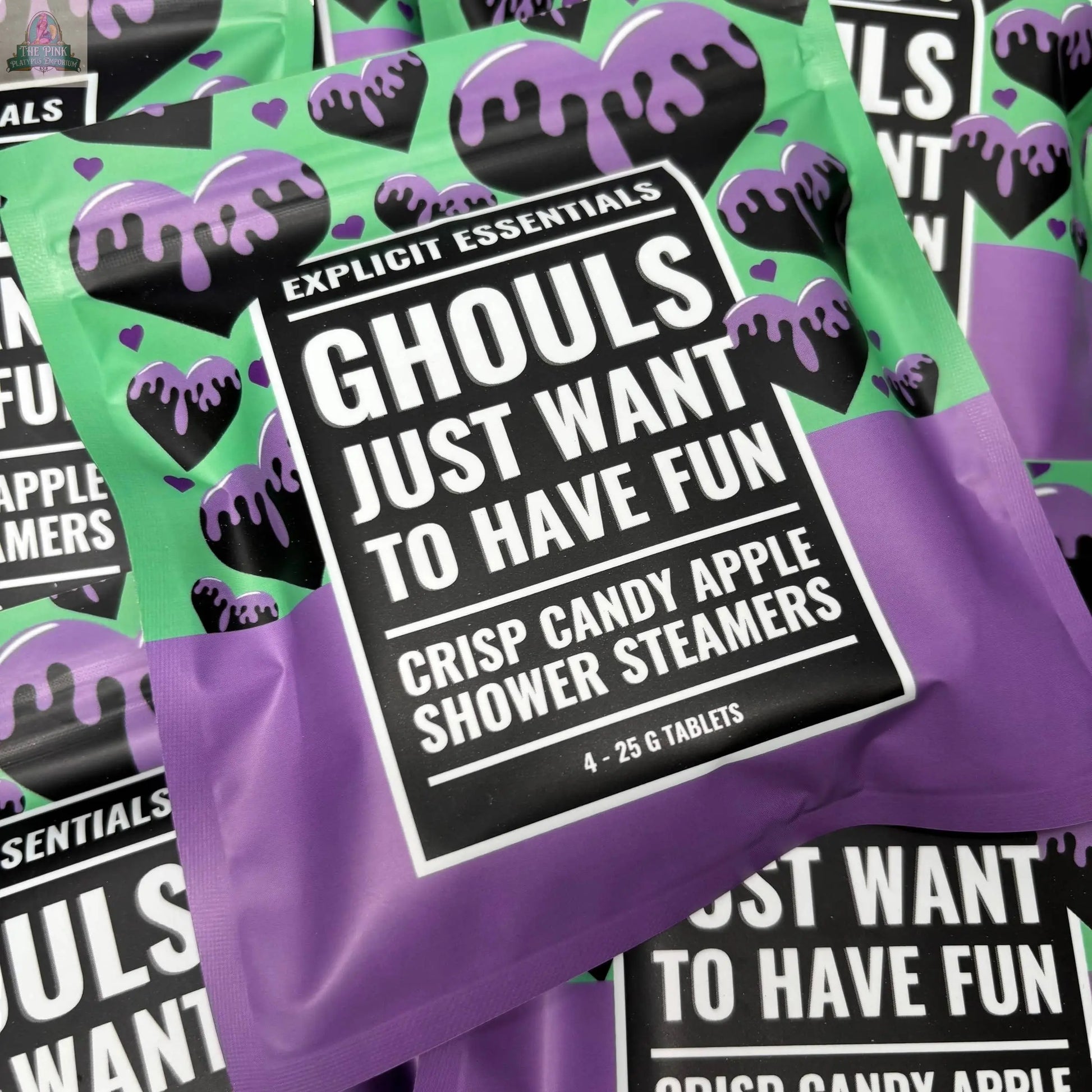 A close-up of colorful packages labeled “Halloween Shower Steamers | Spooky Season Gift” by Explicit Essentials, featuring purple and green designs with dripping accents—perfect for Halloween self-care.
