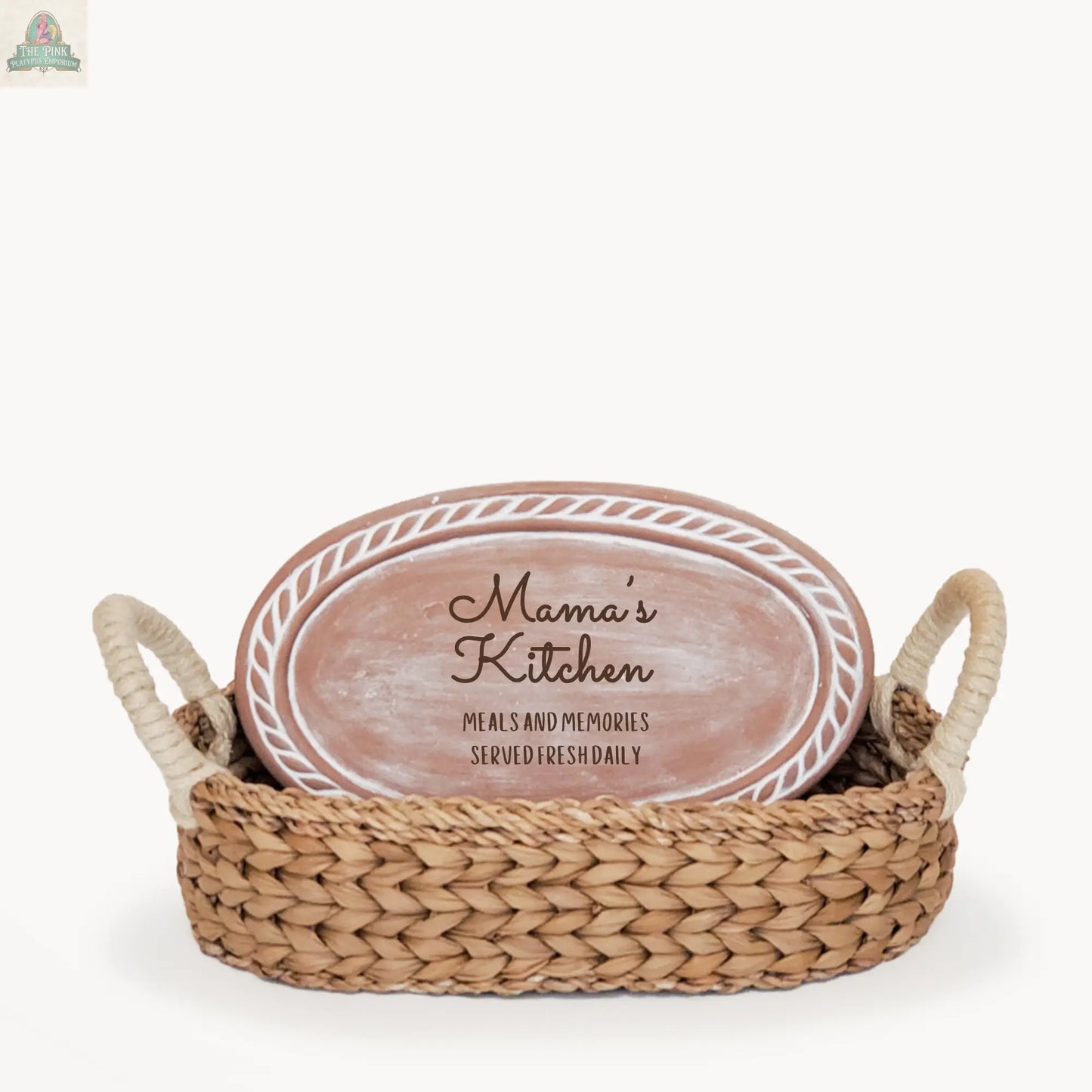 The Handmade Bread Warmer & Wicker Basket - Mom Oval: Design 3 features a seagrass basket with handles and an oval ceramic plaque reading “Mama’s Kitchen – Meals and memories served fresh daily.”.