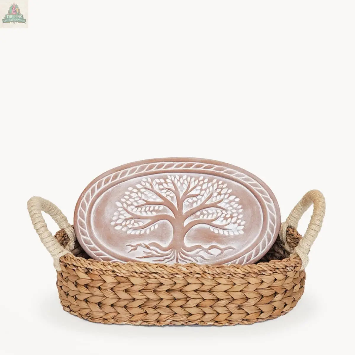 The KORISSA Handmade Bread Warmer & Wicker Basket - Tree of Life Oval features a ceramic plate with a raised tree design in a handled wicker basket, perfect for warming bread or displaying your favorite terracotta stone.