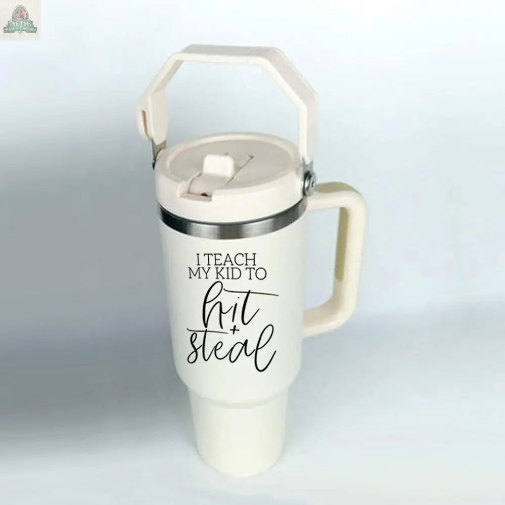 The Hit & Steal 40oz tumbler with handle and lid features "I Teach My Kid to Hit + Steal" in bold black letters—perfect for any baseball mom to show her love for the game wherever she goes.