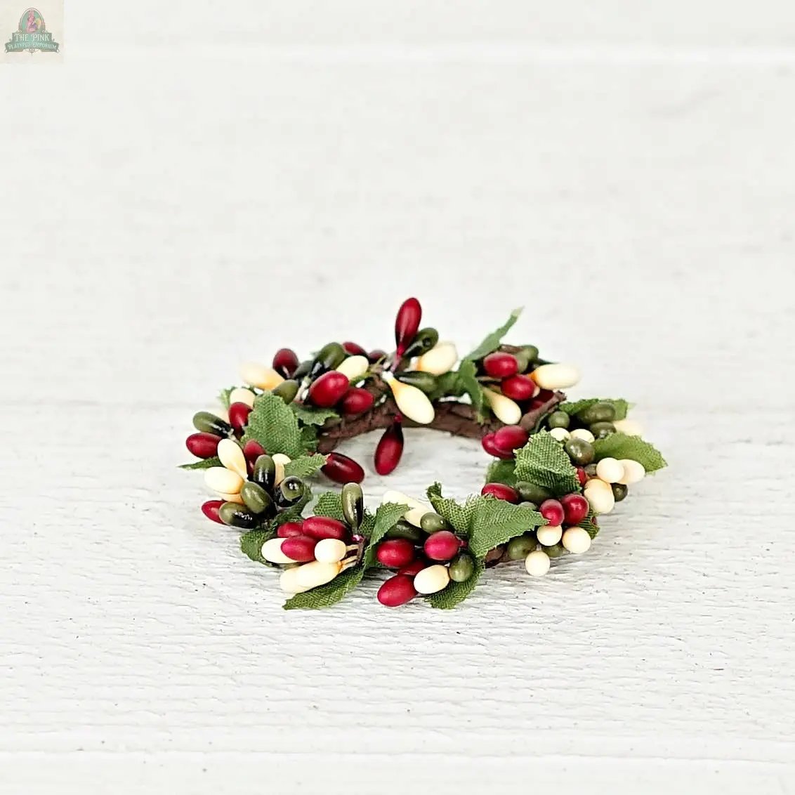 The ISB13700FH 1.5in Pip Berry Taper/Napkin Ring features green leaves and red, white, and yellow berries—ideal as a farmhouse-inspired napkin ring or rustic decoration for your home.